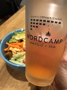 Frosted glass of beer with WordCamp Asheville logo printed on it