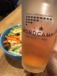 Frosted glass of beer with WordCamp Asheville logo printed on it